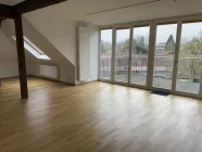 lichtdurchflutetes Wohnzimmer mit Zugang zum Südostbalkon