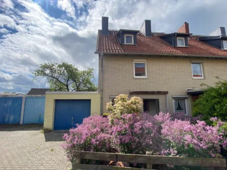 Hausansicht mit 3 Garagen - Haus kaufen in Wolfenbüttel - Kleines, modernisierungsbedürftiges Reihenendhaus mit schönem Grundstück und Garagen