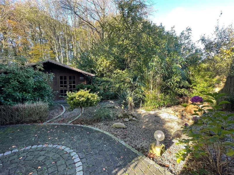 Gartenhaus und Terrasse mit Blick auf Wäldchen