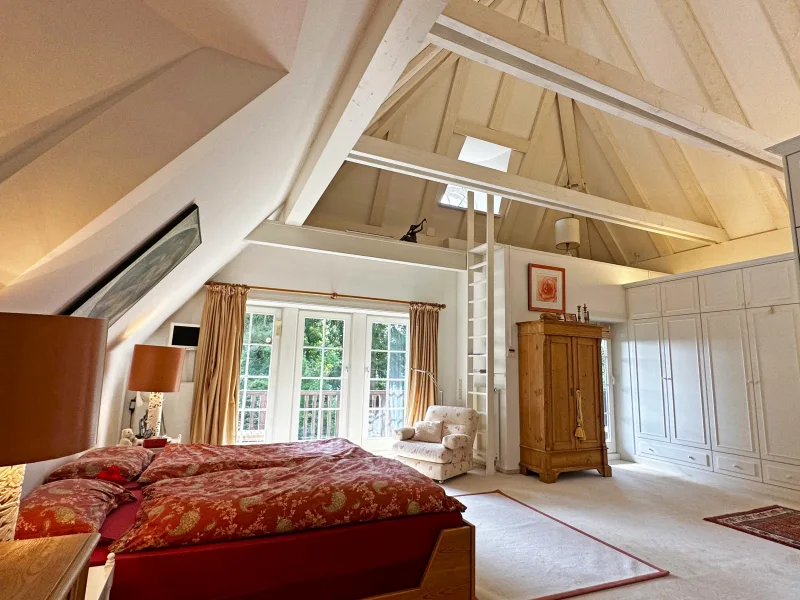 Schlafbereich mit offener Dachkonstruktion und Balkon