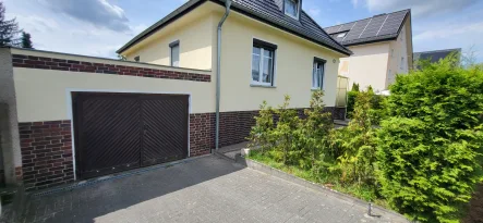 Hausansicht mit Garage - Haus kaufen in Falkensee - Wohntraum mit flexiblem Ausbaupotenzial, geräumiger Garage und  vielseitigem Nebengebäude