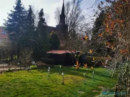 Gerätehaus und Blick zur Dorfkirche