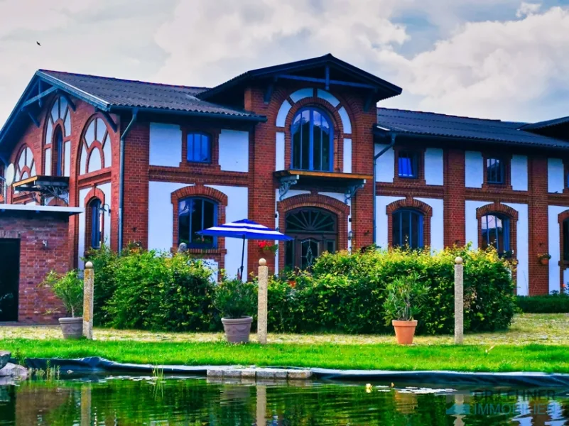 Straßenansicht mit Gartenteich, links die Garage