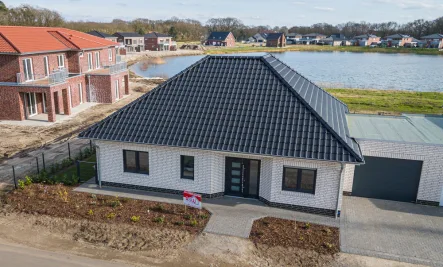 Vorderansicht - Haus kaufen in Herzlake - Neubau Erstbezug !Traumhaftes Wohnen am See! Geräumiger Bungalow KfW55 mit Luftwärmepumpe