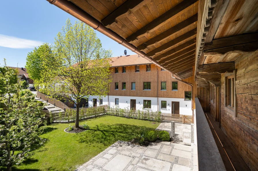 Der Blick vom Balkon auf die beiden Süd-Terrassen und den wunderschönen U-förmig umlaufenden Garten 