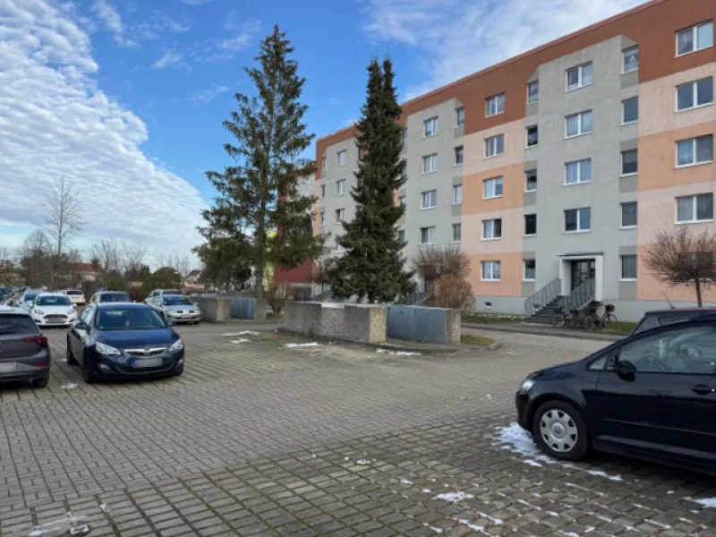 Parkplätze vor dem Haus - Wohnung kaufen in Wurzen - Sofort frei: Plattenbau mit Stil – Der perfekte Mix aus Retro und Modern