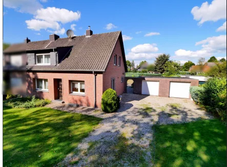 Gebäudeansicht - Haus kaufen in Kleve - Gepflegte Doppelhaushälfte mit Doppelgarage und großem Grundstück in Kleve-Reichswalde