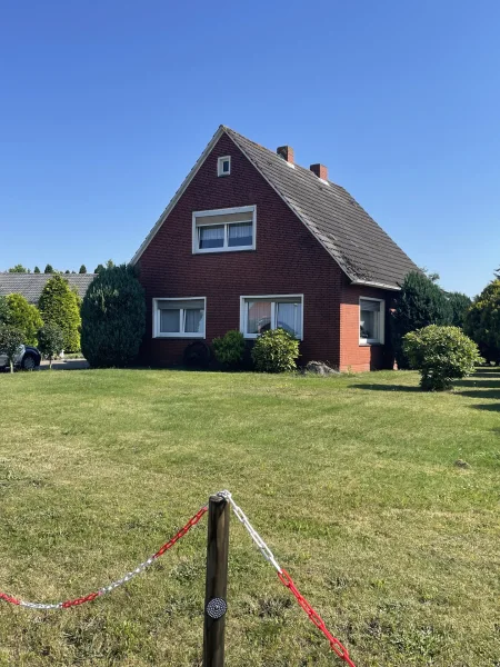 Straßenansicht - Haus kaufen in Weener - Stapelmoor - Familienfreundliches Einfamilienhaus in Weener-Stapelmoor. Mit Potenzial. Provisionsfrei für d. Käufer.