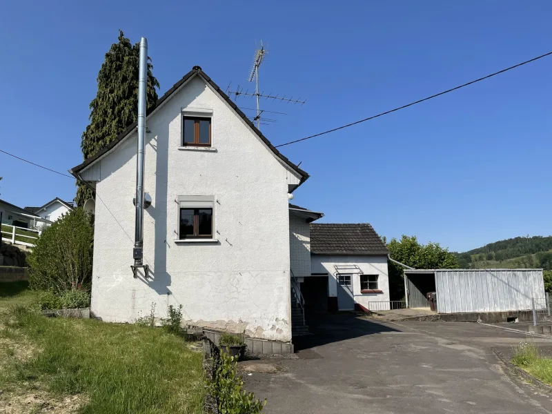 Hausansicht - Haus kaufen in Gummersbach - Kleines Einfamilienhaus mit Garten und zwei Garagen!