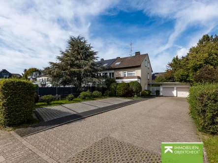 Straßenansicht - Haus kaufen in Ratingen - Doppelhaushälfte mit großem Grundstück, Balkon & Doppelgarage - angrenzend an Grünanlage
