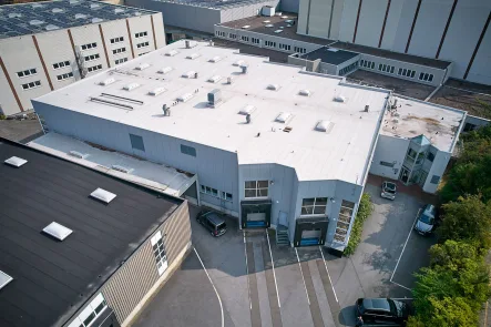 Objektansicht mit Laderampen - Halle/Lager/Produktion mieten in Bielefeld - Vielseitig nutzbare Gewerbehalle mit Laderampen und großem Büroanbau