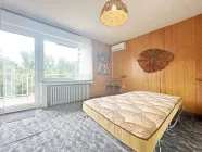 Schlafzimmer mit Tür zum Balkon