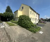 Straßenansicht mit Stellplätzen und Carport