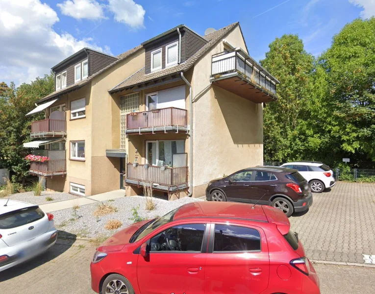 Hausansicht mit seitlichen PKW- Stellplätzen - Wohnung kaufen in Dortmund - Vermietete ca. 64 m² große 2-Zimmerwohnung mit Balkon, modernem Tageslichtbad und PKW-Stellplatz