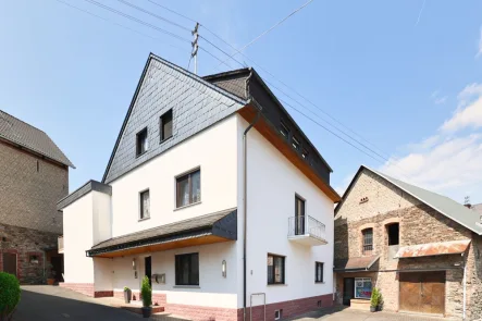 Hausansicht Hof vorne - Haus kaufen in Arzbach - 3-Familien Wohnhaus mit Terrasse, 2 Nebengebäuden, Garagen und Innenhof im Ortskern von Arzbach