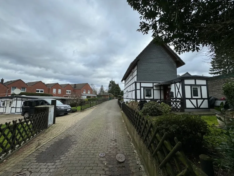Ansicht mit Privatstraße - Haus kaufen in Solingen - Vermietetes Einfamilienhaus, Nebengebäude mit Garage + kleiner Bungalow Nähe SG-Merscheid
