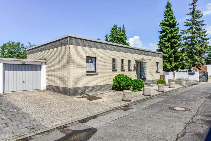 Seitenansicht - Haus kaufen in Köln - Freist. Flachdachbungalow * ca. 121,33 m² Wohnfl. + ca. 86,84 m² Nutzfl. * eingefriedeter Garten + Terrasse * ca. 496 m² Grund * Doppelgarage * wohnliche Räume + großes, zweites Bad im KG 