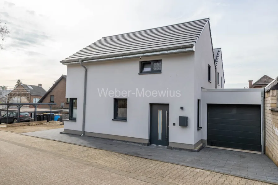 3383 Außenansicht vorne - Haus kaufen in Bedburg / Broich - Freistehendes Wohnhaus mit zwei Einheiten (KfW 55),Terrasse, Loggia und Garage