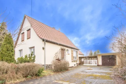 Außenansicht - Haus kaufen in Doberschütz - Charmantes Einfamilienhaus mit großem Garten, Garage und mit Raum für Modernisierungen.