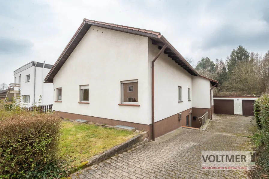 Straßenansicht - Haus kaufen in Bexbach - WOHLFÜHLOASE - Einfamilienhaus mit Einliegerwohnung und zwei Garagen in Bexbach!