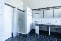 modernes Bad mit großer Dusche und gefliestem Dopp elwaschtisch 