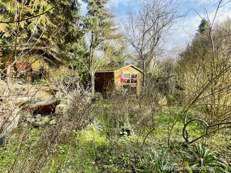 Ein Gartenhäuschen steht ganz hinten