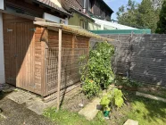 Gartenhäusschen mit Beet hinter Garage