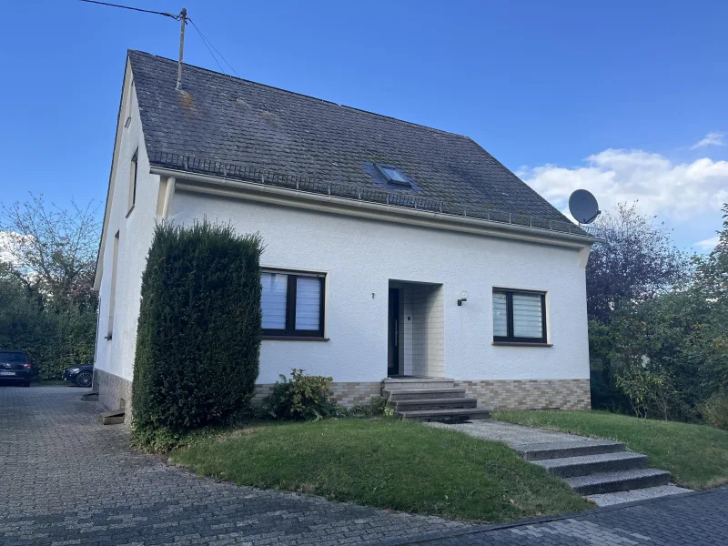 Straßenansicht - Haus kaufen in Krunkel - Gepflegtes und vermietetes Einfamilienhaus mit sep. Baugrundstück in schöner, ruhiger Wohnlage