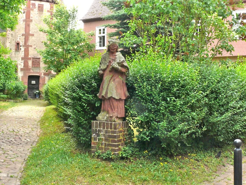 Ein gepflegter und romantische Garten mit historischen Figuren und Gebäude