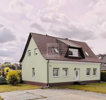 Seitenansicht in Blick in Richtung Immobilie - Zinshaus/Renditeobjekt kaufen in Steinbeck - Vermietetes Zweifamilienhaus inkl. Garten –Top Kapitalanlage in Höhenland, nur 19 km bis Eberswalde!