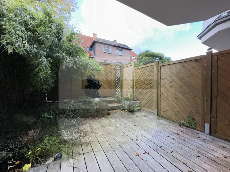 Großzügige Terrasse mit Holzdielen und separatem Ausgang zur Garagenzufahrt