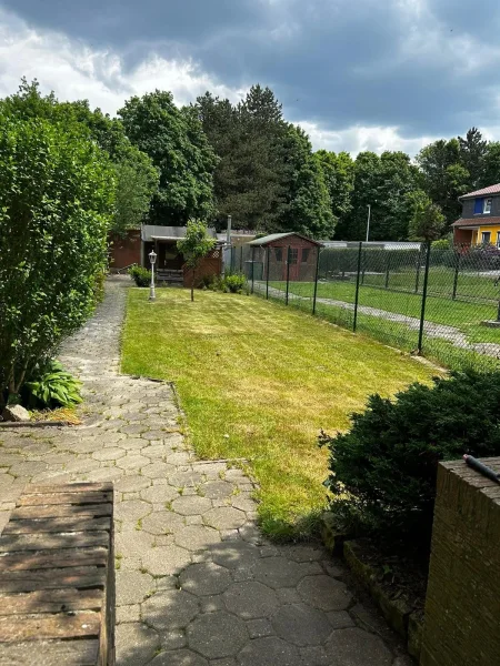 Blick von der Terrasse in den Garten Richtung Garagen