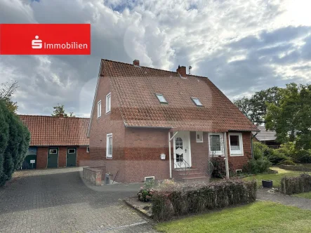 Straßenansicht mit Hauseingang separatem Kellerzugang und Zufahrt Nebengebäude - Haus kaufen in Martfeld - Solides Zweifamilienhaus mit Nebengebäude und zusätzlichem Bauplatz