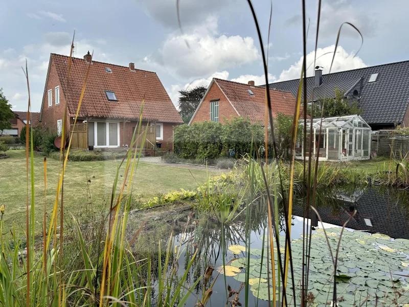 Blick von der hinteren Grenze auf Haus und großer Teichanlage