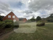 Blick von der rechten Straßenecke auf Haus und der freien zur Bebauung geeigneten Gartenfläche