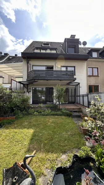 Garten mit Hausansicht - Wohnung kaufen in Köln / Dellbrück - Gemütliche Gartenwohnung in ruhigem Mehrfamilienhaus
