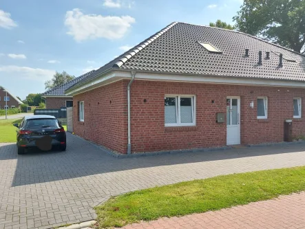 Straßenansicht  - Haus kaufen in Strackholt - Doppelhaushälfte, Bungalow in schöner Siedlungslage mit Ausbaureserve