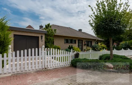 Strassenansicht mit Garage - Haus kaufen in Saterland / Strücklingen - Charmanter Bungalow mit Garage und tollem kleinen Garten