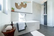 Badezimmer mit Badewanne und bodentiefer Dusche