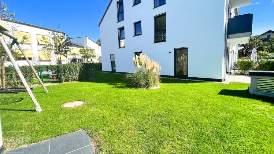 Garten - Wohnung kaufen in Grasbrunn - Moderne 3-Zimmer-Wohnung mit erstklassiger Ausstattung und großem Garten // 105 m² Nutzfläche