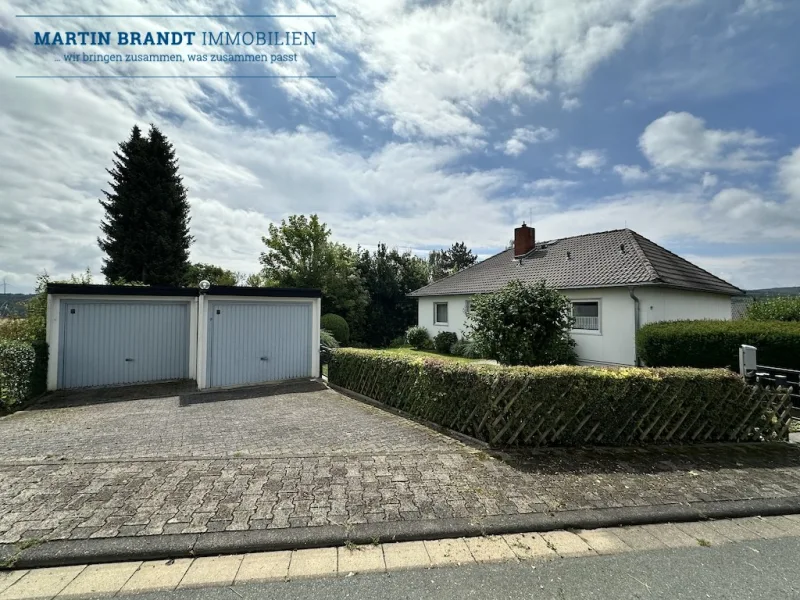 Blick auf das Haus und Garage - Haus kaufen in Hünstetten-Beuerbach - Charmantes Einfamilienhaus mit ELW und Garten in traumhafter Feldrandlage von Hünstetten-Beuerbach