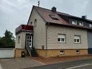 Außenansicht mit Stellplätzen und Garage