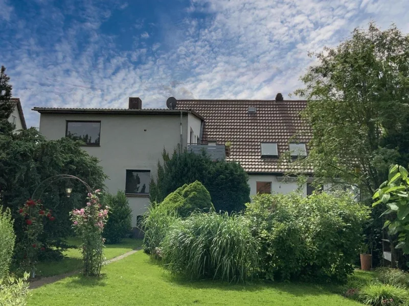 Garten mit Wohnhausansicht - Haus kaufen in Katlenburg-Lindau - Großzügige Doppelhaushälfte mit traumhaftem Garten und Doppelgarage!