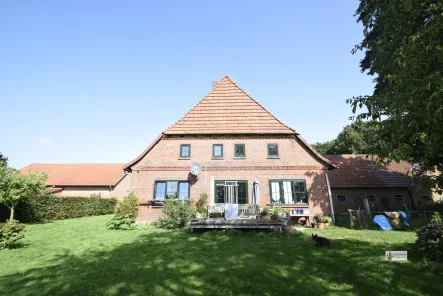 Südansicht mit Terrasse - Haus kaufen in Sudwalde - Solides Bauernhaus mit großem Stallgebäude und 5.000 m² Grundstück in Sudwalde