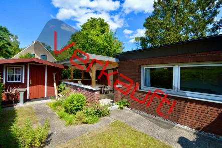 Eingangsseite mit Gartenhaus und überdachter Terrasse - 1 - Haus kaufen in Lübeck - BUNGALOW-REFUGIUM AUF DEM TRAVEMÜNDER PRIWALL DIREKT AN DER OSTSEE