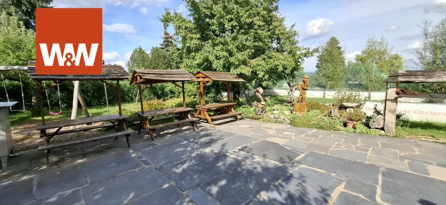 Blick vom Balkon auf die gepflasterte Hoffläche mit Spielplatz