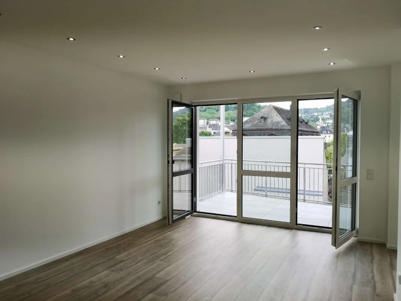 Wohnzimmer und Balkon - Wohnung kaufen in Bingen am Rhein - LICHTDURCHFLUTETE WOHNUNG IM ORTSKERN VON BINGEN – MODERN, ENERGIEEFFIZIENT UND KOMFORTABEL