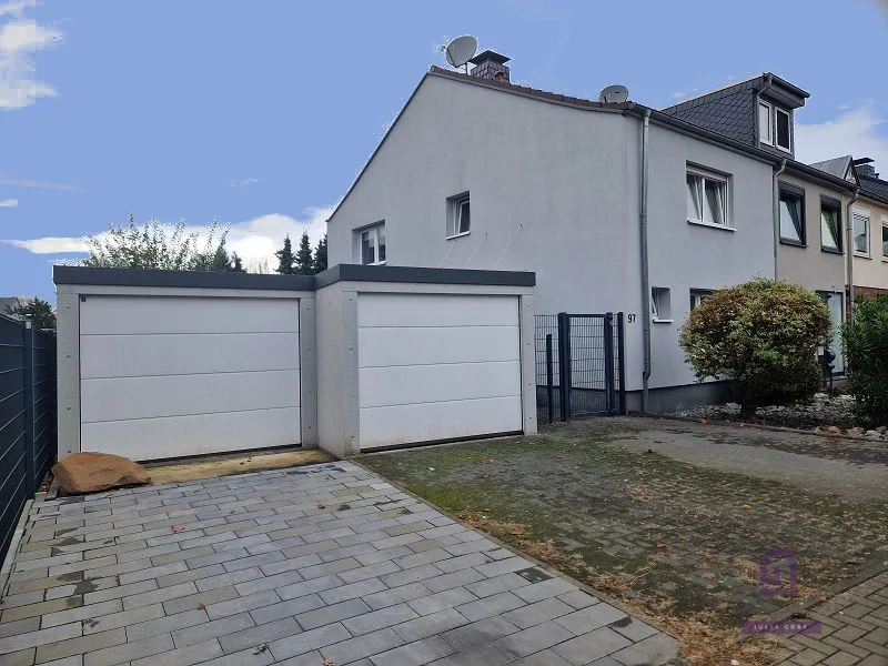 Ansicht mit Garagen - Haus kaufen in Köln - renoviertes Reiheneckhaus mit zwei Garagen in Köln-Holweide