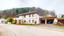 Haus Vorderseite mit großen Garagen und Stellplätzen